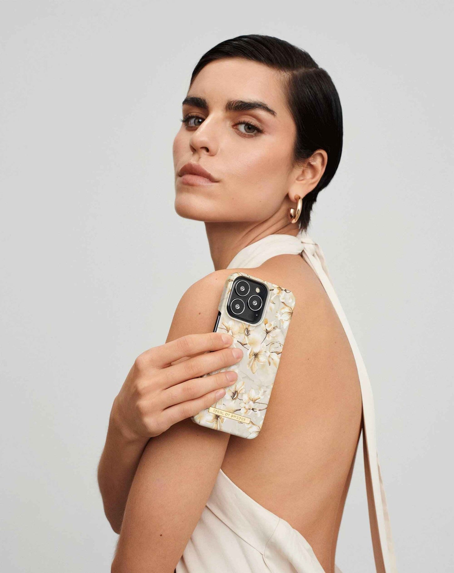 Mobildeksel iPhone 8/7/6/6S/SE Pearl Blossom fra IDEAL OF SWEDEN, med blomstermotiv, holdt av modell.